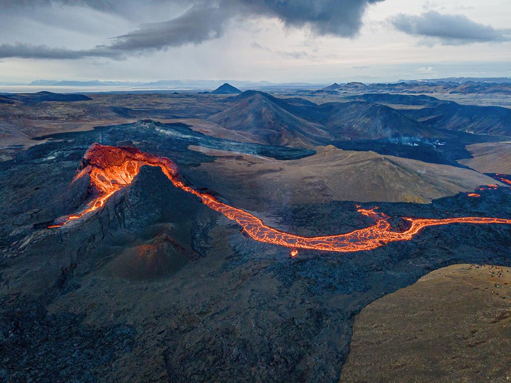 Aerial view towards the SW over the active cone and the lava flow. Reykjanes southern coastline is visible in the background. (Photo: World-Geographic)