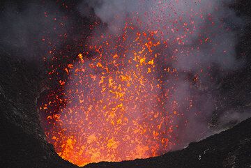 Liquid spatter is ejected several meters above the crater rim of the south pit when larger gas bubbles burst at the surface of the lava lake. (Photo: Tom Pfeiffer)