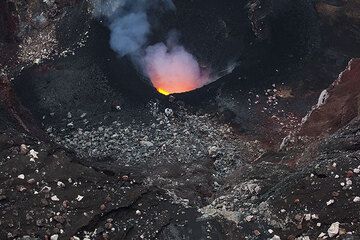 Mit einer weißen Kruste überzogene Trümmer aus den steilen inneren Wänden des Kraters und frische schwarze Lapilli um den Schlot herum. (Photo: Tom Pfeiffer)