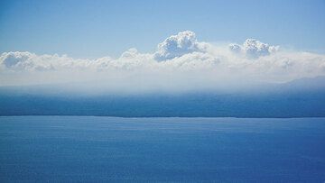 Bei der Annäherung an Ambrym erkennt man die dichte vulkanische Nebel- und Gaswolke über der Kaldera.  (Photo: Tom Pfeiffer)