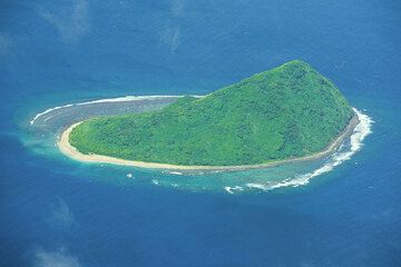 Remnants of an old, eroded volcanic cone now forming a small island surrounded by a reef.  (Photo: Tom Pfeiffer)