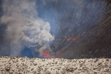 One of the several vents in the south crater was constantly pulsating dense clouds of hotdense ash and small fragments, still incandescent near the vent. A small ring-fracture like vent behind emits a small lava flow. (Photo: Tom Pfeiffer)