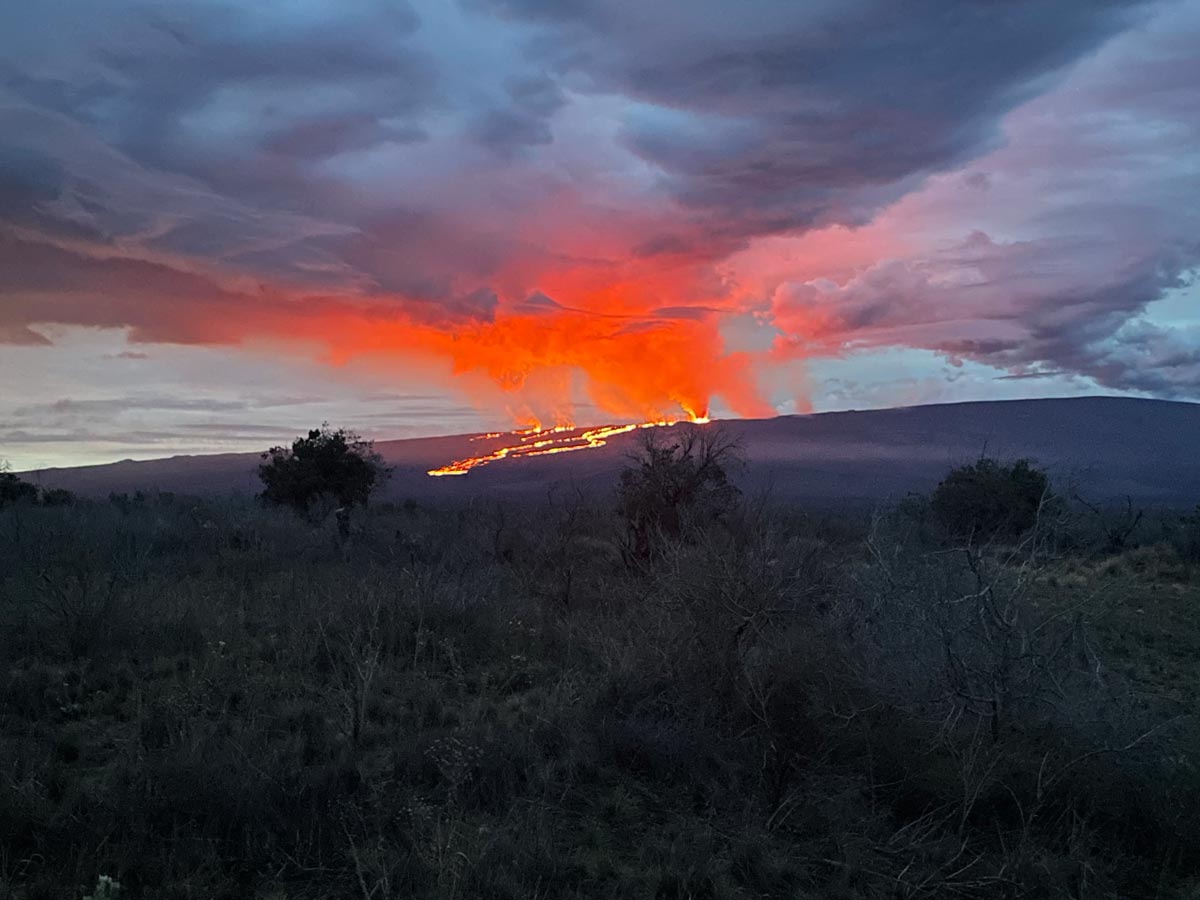 Photograph taken from Saddle Road at 6AM Hawaii time on November 29, 2022 shows lava flows moving northeast downslope of Mauna Loa volcano from the Northeast Rift Zone eruption. (image: HVO / USGS)