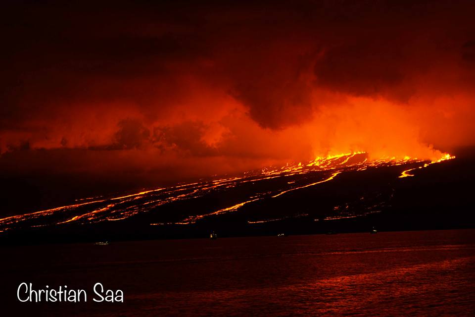 The nighttime sky is turned red due to the red glow from the lava fountaining from the fissures, forming multiple rivers flowing towards the ocean (image shared on Facebook page of Christian Saá)