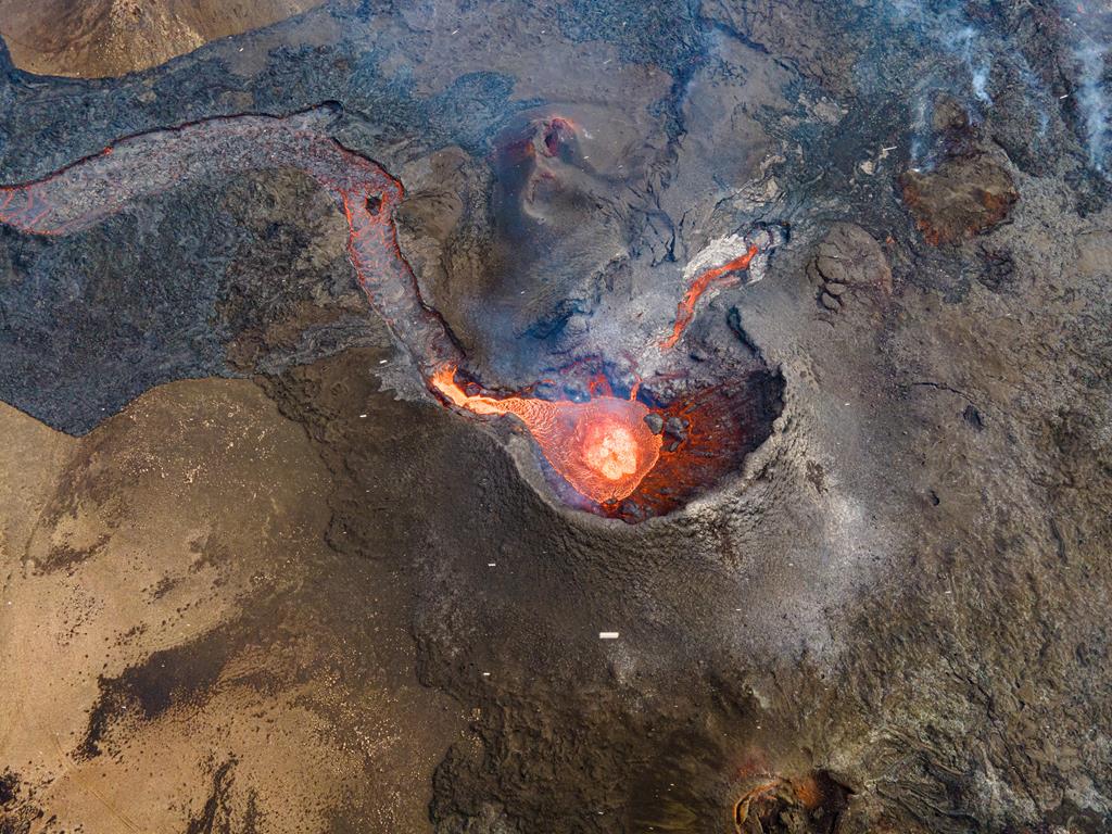Vertical aerial shot into the main cone during a quiet phase; a small pond of lava fills the vent.