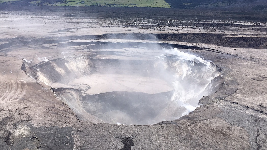HVO scientists captured this aerial view of a much-changed Halema‘uma‘u during their overflight of the summit on the afternoon of June 5.  Explosions and collapse within Halema‘uma‘u have enlarged the crater (foreground) that previously hosted the summit lava lake, and the far rim of Halema‘uma‘u has dropped with continued summit deflation. (HVO/USGS)