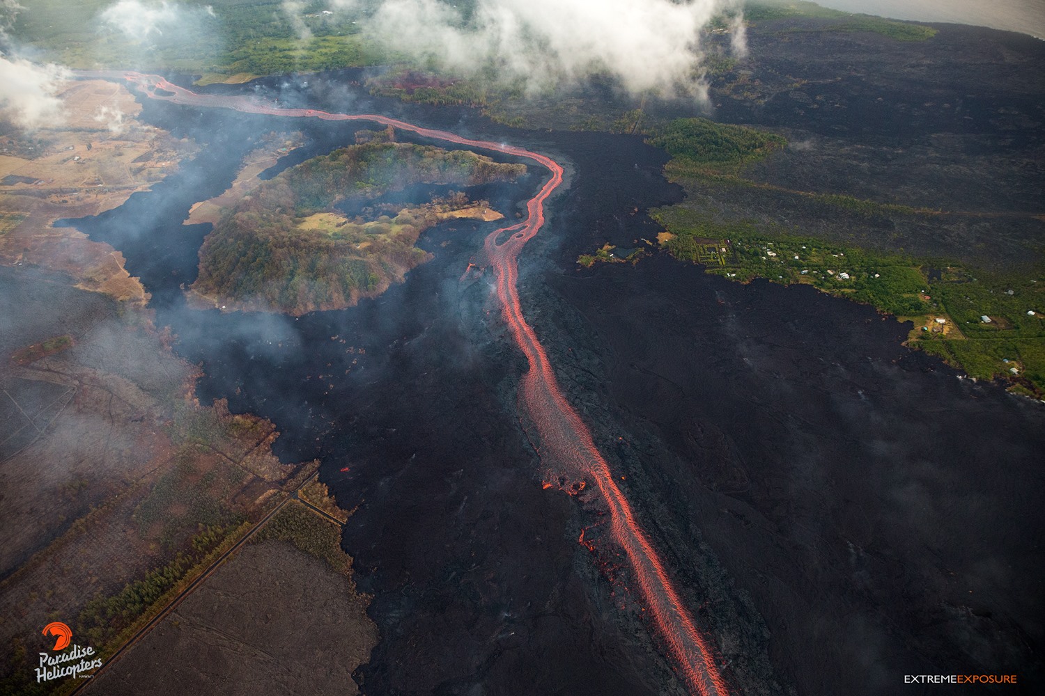 This aerial image taken on Sunday morning 24 June 2018, shows the  section of the channelized flow below Kapoho crater where the lava is ponding  and overflowing at its edges, send ...