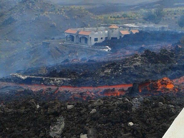 The lava flow of Fogo passing near a destroyed building (image: INVOLCAN / @involcan / twitter)