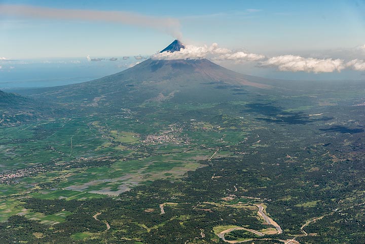 A light ash plume can be seen rising from the top of the volcano where the active vent of the 2018 eruption lies. The volcano forms a prominent landmark, rising to 2462 m elevation from near sea level out of the otherwise flat landscape of the Albay Gulf.