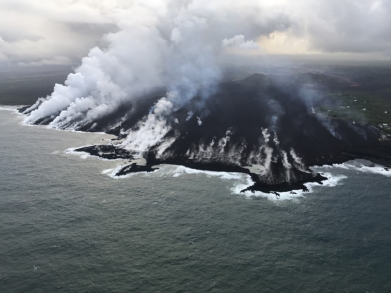 Aerial view of the ocean entry at Kapoho, where a lava delta about 250 acres in size is filling the bay, early morning of June 12, 2018. At this time, the south side of the ocean entry was most active, with many small streams of lava and corresponding steam plumes spread along a fairly broad section of the southern part of the delta. (HVO/USGS)