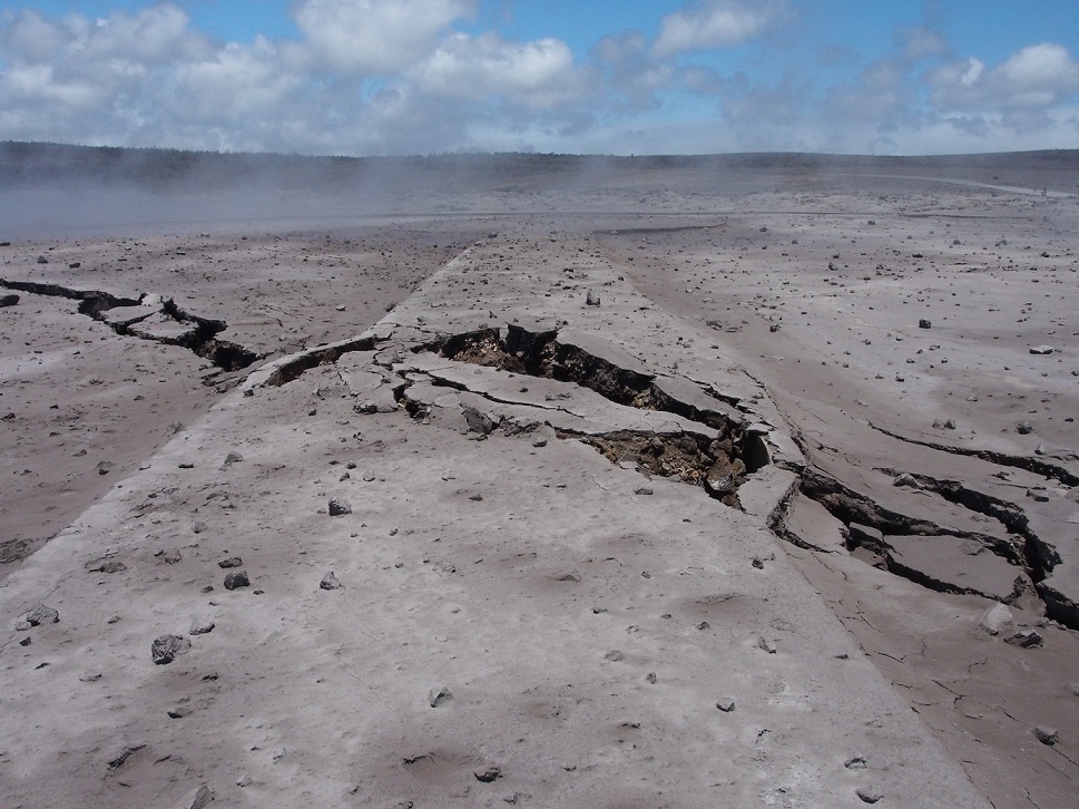 The median between two areas of the Halema’uma’u parking lot has been warped and broken by cracks. Ash accumulation in the parking area was generally not more than 4 cm (1.5 in) thick. (HVO/USGS)