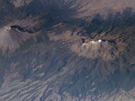 Photo from the International Space Station showing a pair of volcanoes in Mexico: active Popocatepetl (left) and extinct Iztaccíhuatl.(right).