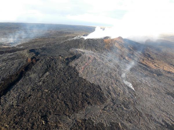 As of 27 May, the flows were spreading laterally near the vent, but making little forward progress; as a result, they were not posing a threat to any community. The silvery sheen of new lava erupting from the northern breakout (center) and eastern breakout (far left) stands out in contrast to the older flows on and around Puʻu ʻŌʻō. (image taken on 27 May / USGS)