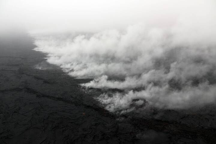 A new crack 1 km (0.6 mile) long was found on the west (uprift) side of Pu‘u ‘Ō‘ō during HVO's overflight on 1 May. The cracking appeared to be nearly continuous en echelon structures that were heavily steaming. A small amount of lava was apparently erupted from the crack, based on the presence of nearby tiny pads of lava and spatter, but it was no longer active when HVO geologists saw it during the overflight. This photo looks east, with Pu‘u ‘Ō‘ō obscured by low clouds in the upper left corner. (image: HVO / USGS)