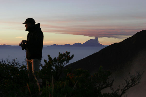 Hans-Georg on Welirang at sunrise, erupting Semeru in the far background