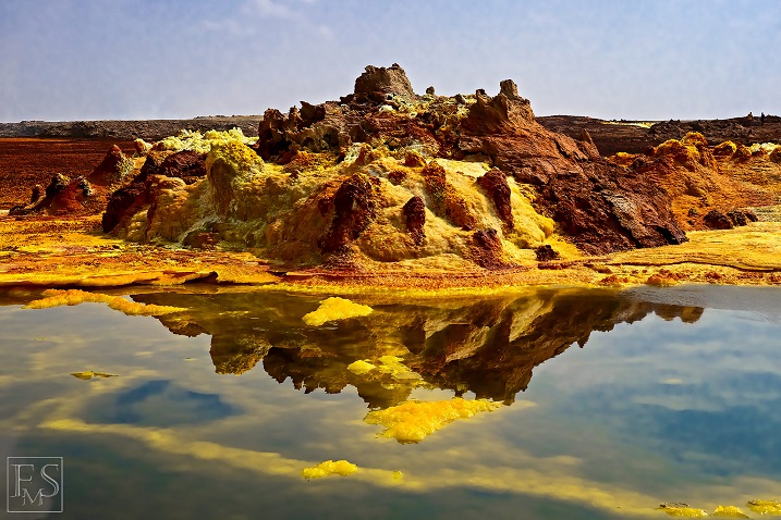 Yellow-brown salt deposits and small geysirs reflect in one of the many acid pools at the hydrothermal site of Dallol (Stefan Tommasini - January 2018)