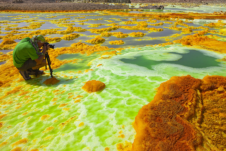 Photographing the abundant green acid ponds amidst the white-yellow-orange salt deposits (Dec 2010; image: Tom Pfeiffer)
