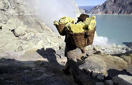 Les ouvriers, locaux portant des paniers avec jusqu' à 50kg de blocs de soufre remontant du fond du cratère pour redescendre de l’autre côté.
