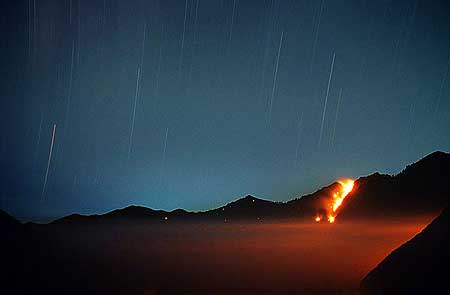 Nighttime view onto the Tengger caldera with forest fire on the caldera wall