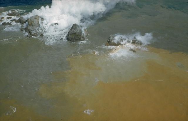 Steam pours from the blocky summit of a lava dome formed at Myojin-sho during a submarine eruption at the Bayonnaise Rocks volcano in 1952. This September 22 photo was taken 6 days after the dome began to breach the sea surface. Later that day the eruption became highly explosive, and the dome was destroyed. Three cycles of dome growth and destruction occurred until October 1953. Myojin-sho is located on the eastern rim of a 7-9 km wide submarine caldera. (Photo: Helen Foster / USGS)