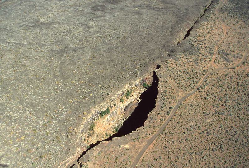 Kings Bowl and Great Rift from air. King's Bowl is a phreatic explosion pit 280 feet (90 m) long, 100 feet (30 m) wide, and 100 feet (30 m) deep, caused by lava meeting groundwater and producing a steam explosion 2,200 years ago. (NPS photo)