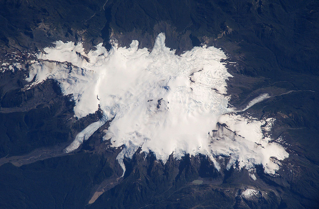 Glacier-covered Volcán Minchinmávida is elongated along a NE-SW direction. The volcano has a mostly obscured 3-km-wide caldera, and a youthful eruptive center is located on the ENE side of the complex. An eruption from Minchinmávida was reported in 1742. Darwin observed the volcano in activity in 1834 on his renowned voyage that took him to the Galápagos Islands. (NASA International Space Station image ISS006-E-42260, 2003, http://eol.jsc.nasa.gov/)