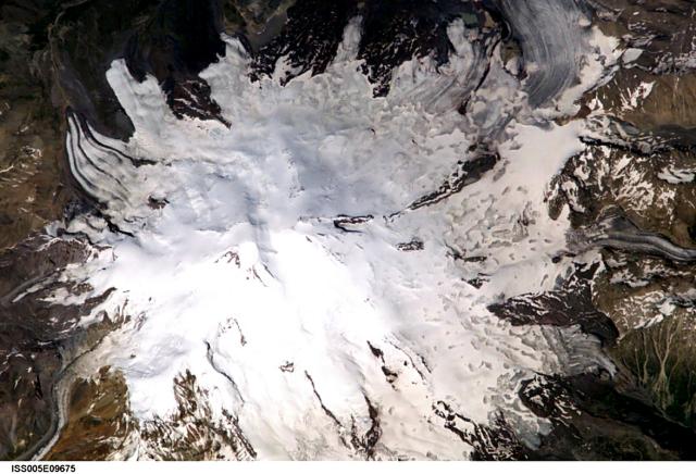 Glaciers radiate from Mount Elbrus, the highest peak of the Caucasus Mountains of SW Russia. Snow-filled craters are visible in this image at both the 5595-m-high eastern summit and the 5633-m-high western summit. Image courtesy of Earth Sciences and Image Analysis Laboratory, NASA Johnson Space Center, 2002