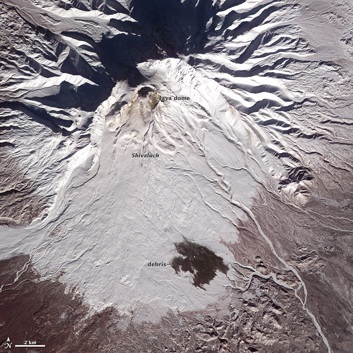 Shiveluch volcano on a Terra satellite image from 19 Feb 2012. Volcanic debris is seen on the lower flanks; the debris traveled about 10 kilometers (6 miles) from Shiveluch’s growing lava dome. (Nasa Earth Observatory)